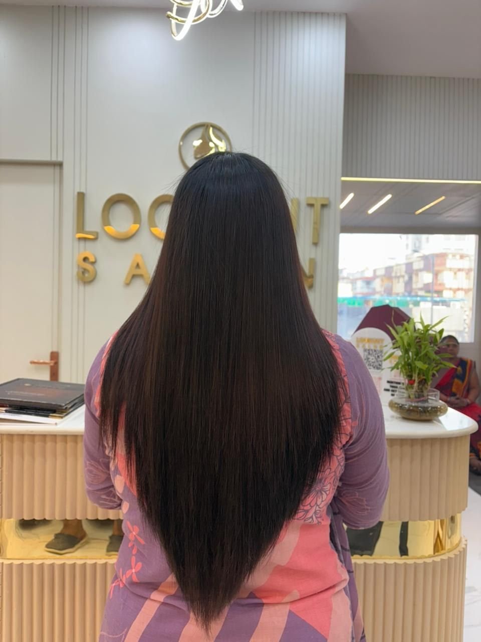 Back view of long, layered, straight black hair at the reception area