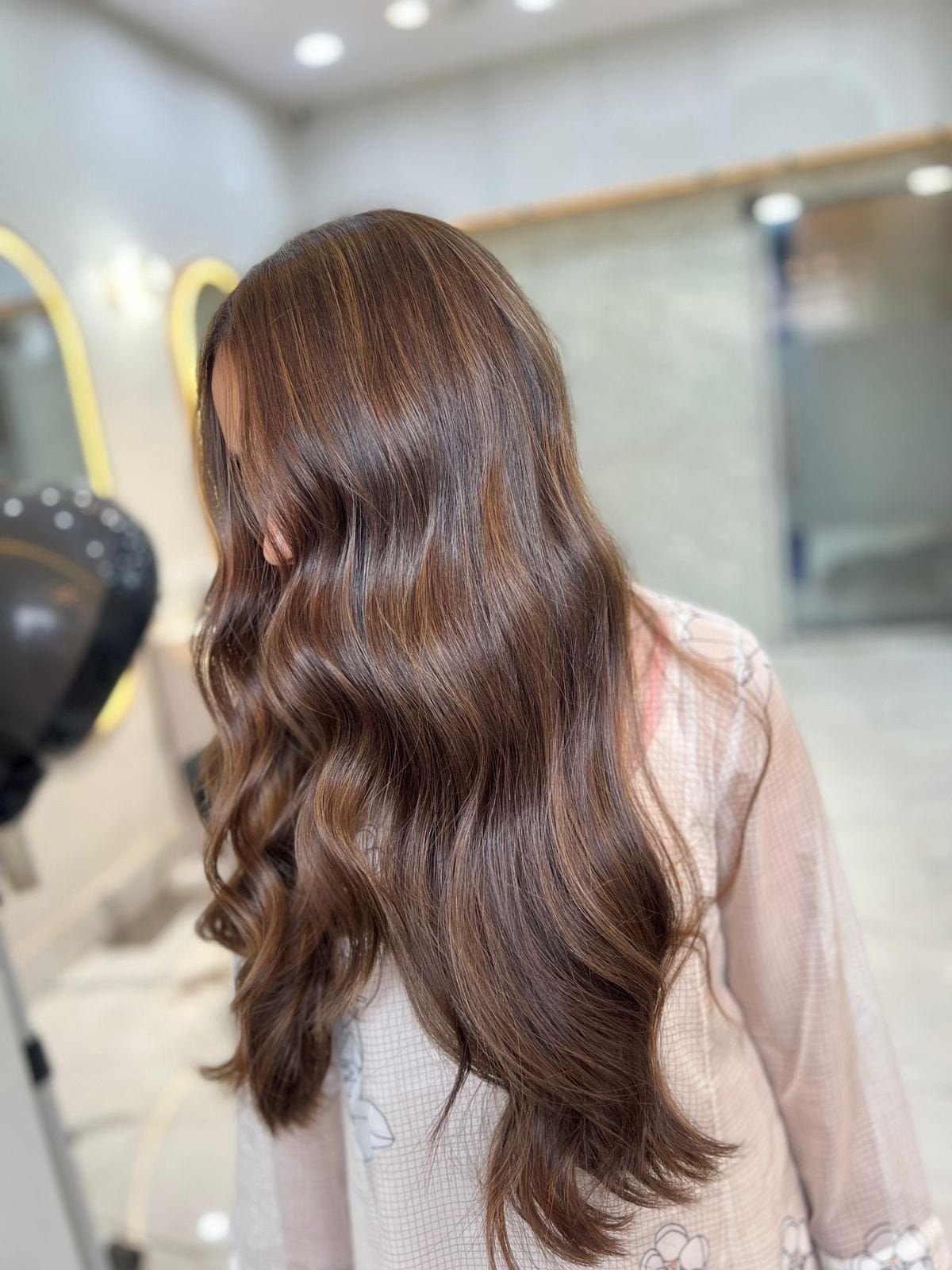 Back view of long brown hair styled in loose waves