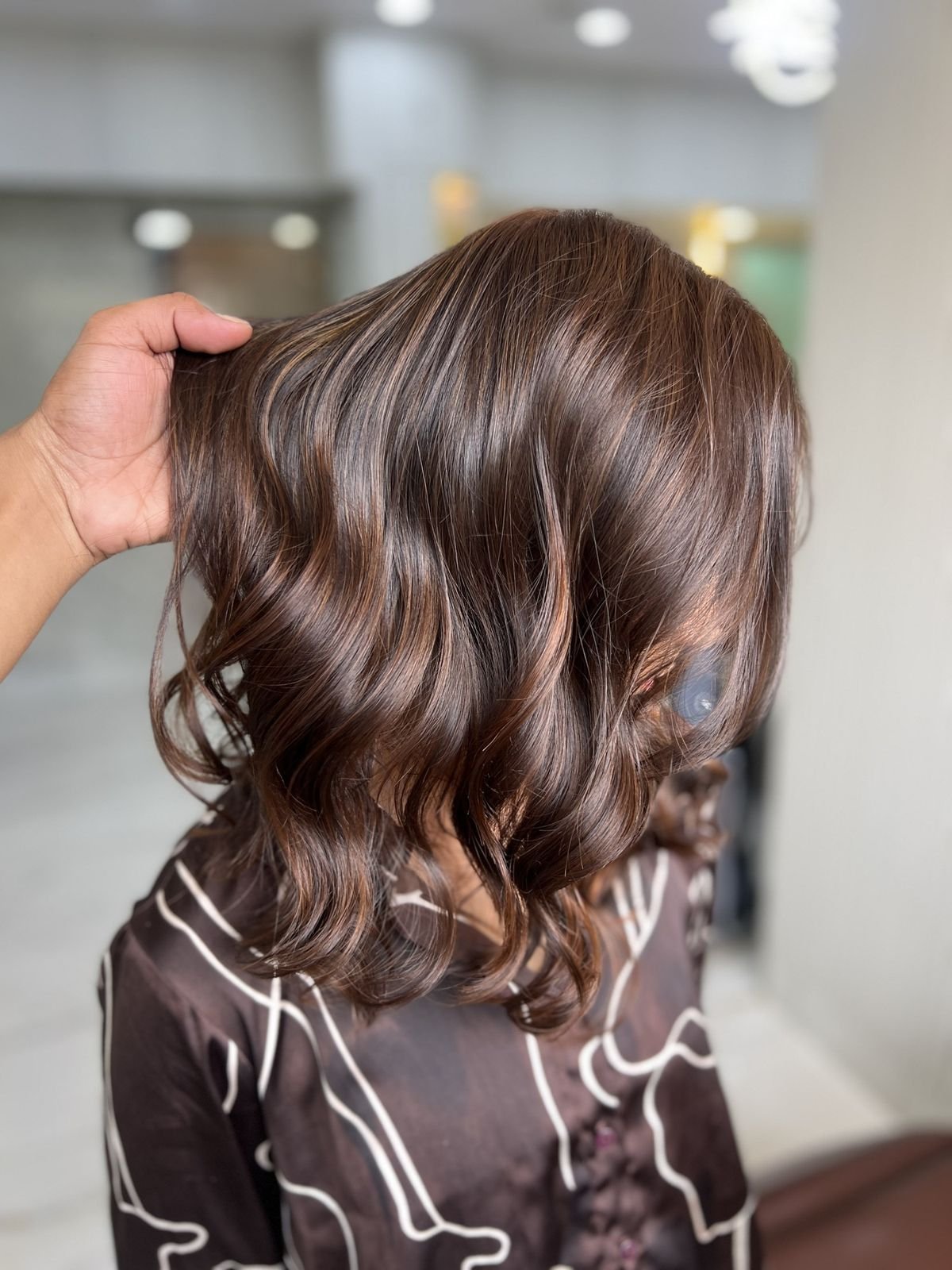 Wavy shoulder-length hair in brown shades with highlights