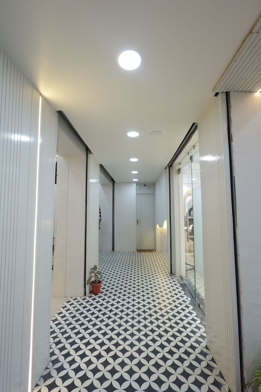Salon corridor with a black and white patterned floor and recessed lighting