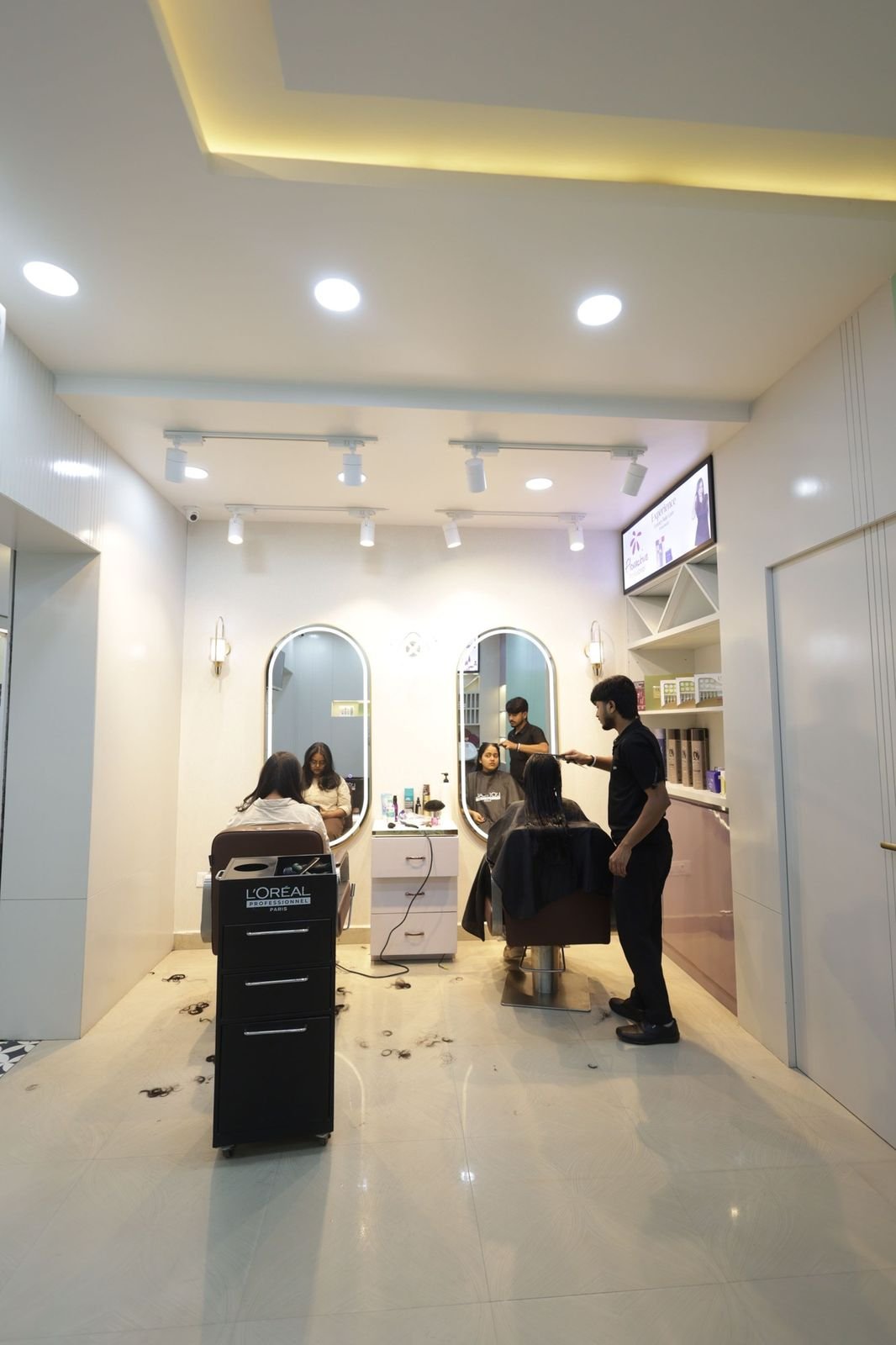 Styling area with arched mirrors, where a stylist works with a seated client